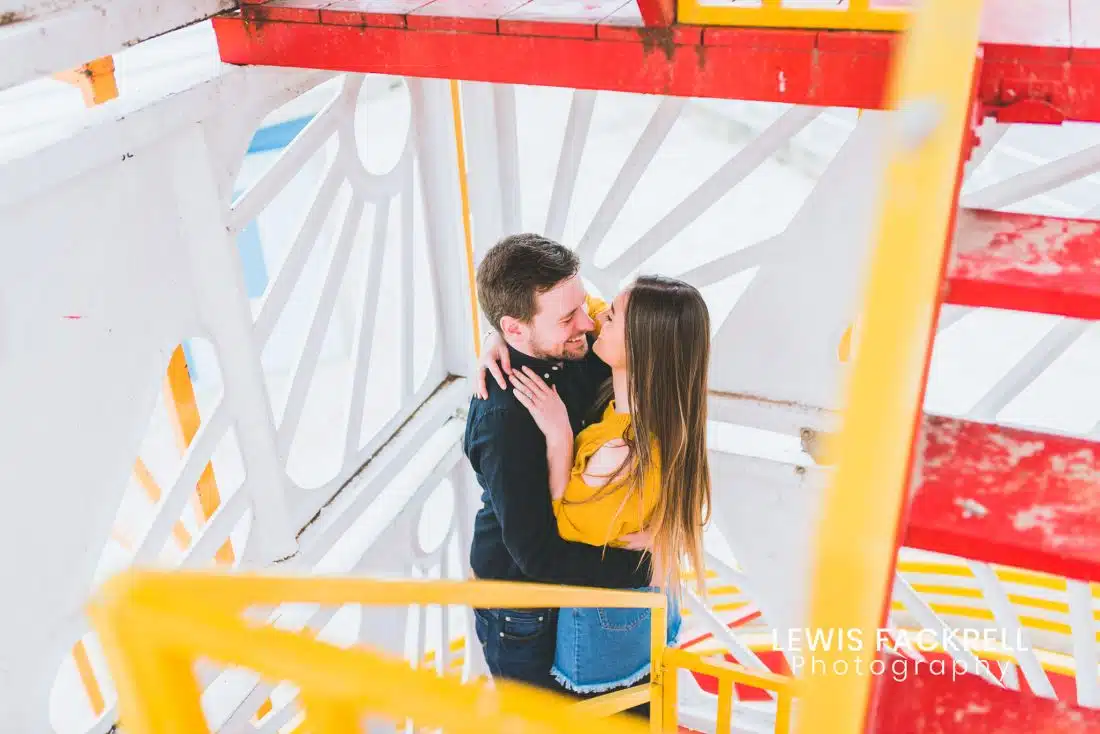 Weymouth pre-wedding photography session of couple on helter skelter