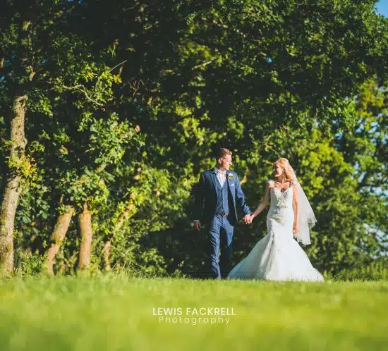 canada lodge, cardiff wedding photography of couple walking along the tree line at the venue holding hands
