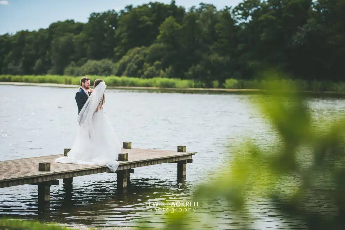 Hensol Castle Wedding photography of bride and groom stood on jetty at venue