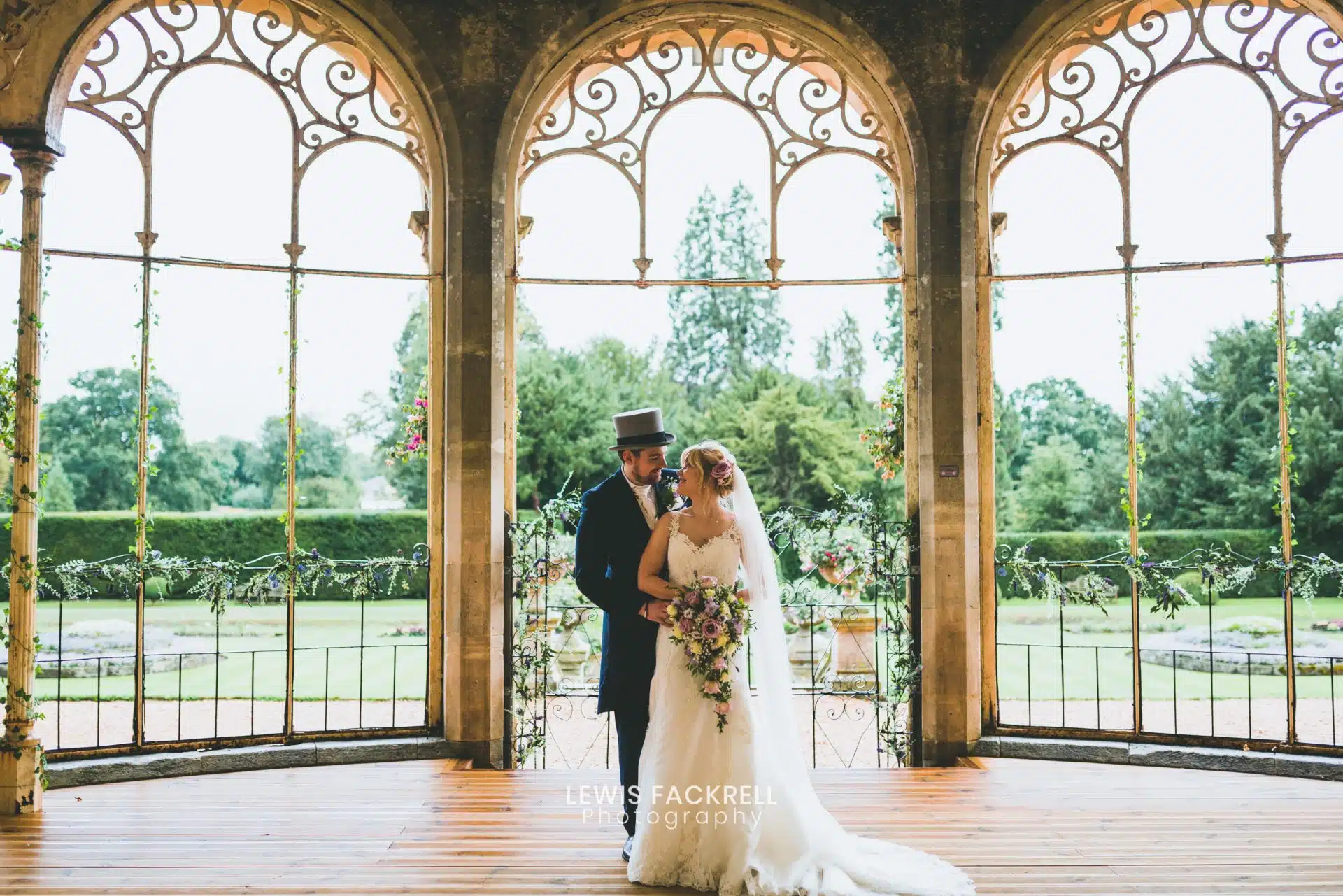 Jennie and Will framed by the arched windows of the orangery at Grittleton House, Wiltshire
