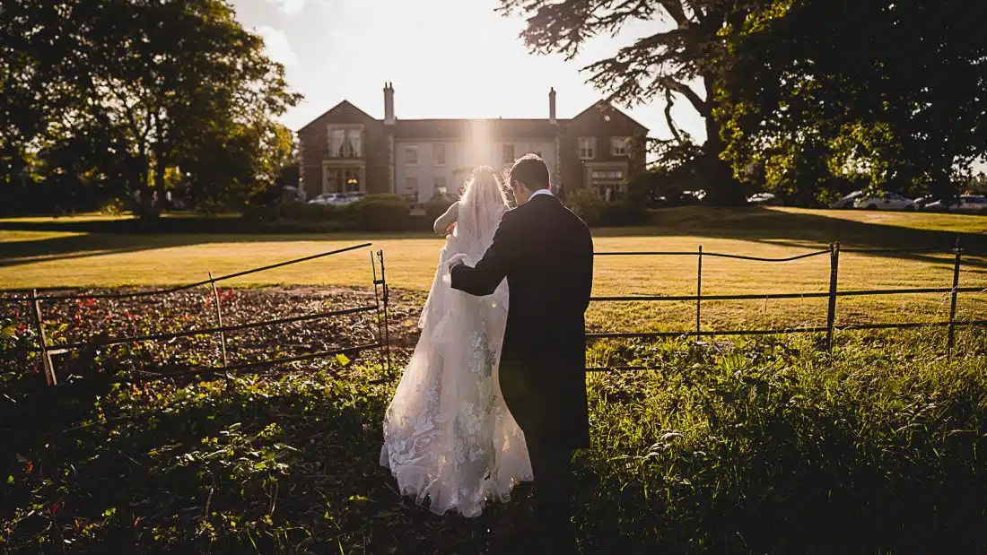 glewstone court wedding, bride and groom walking over lawn