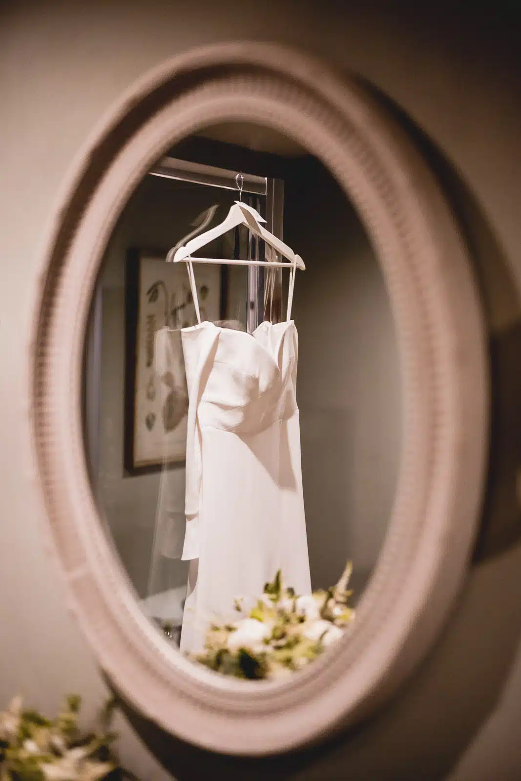 Wedding dress hanging in the mirror at the Barn at Upcote