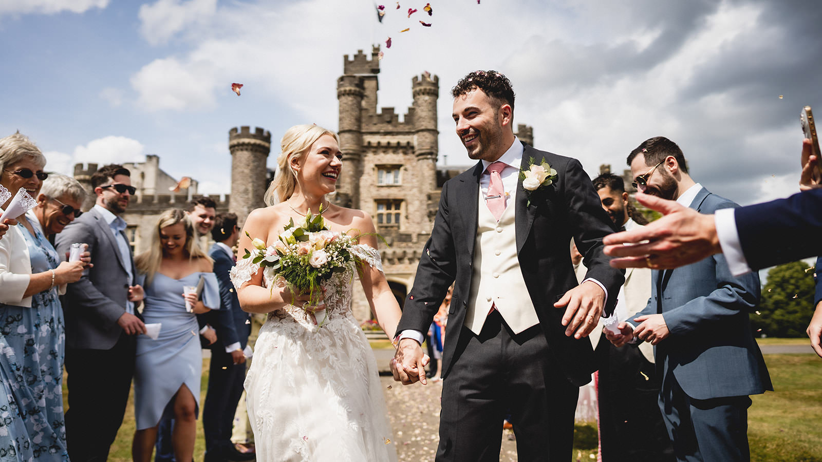 hensol castle in the background as the couple walk towards me during confetti throwing.