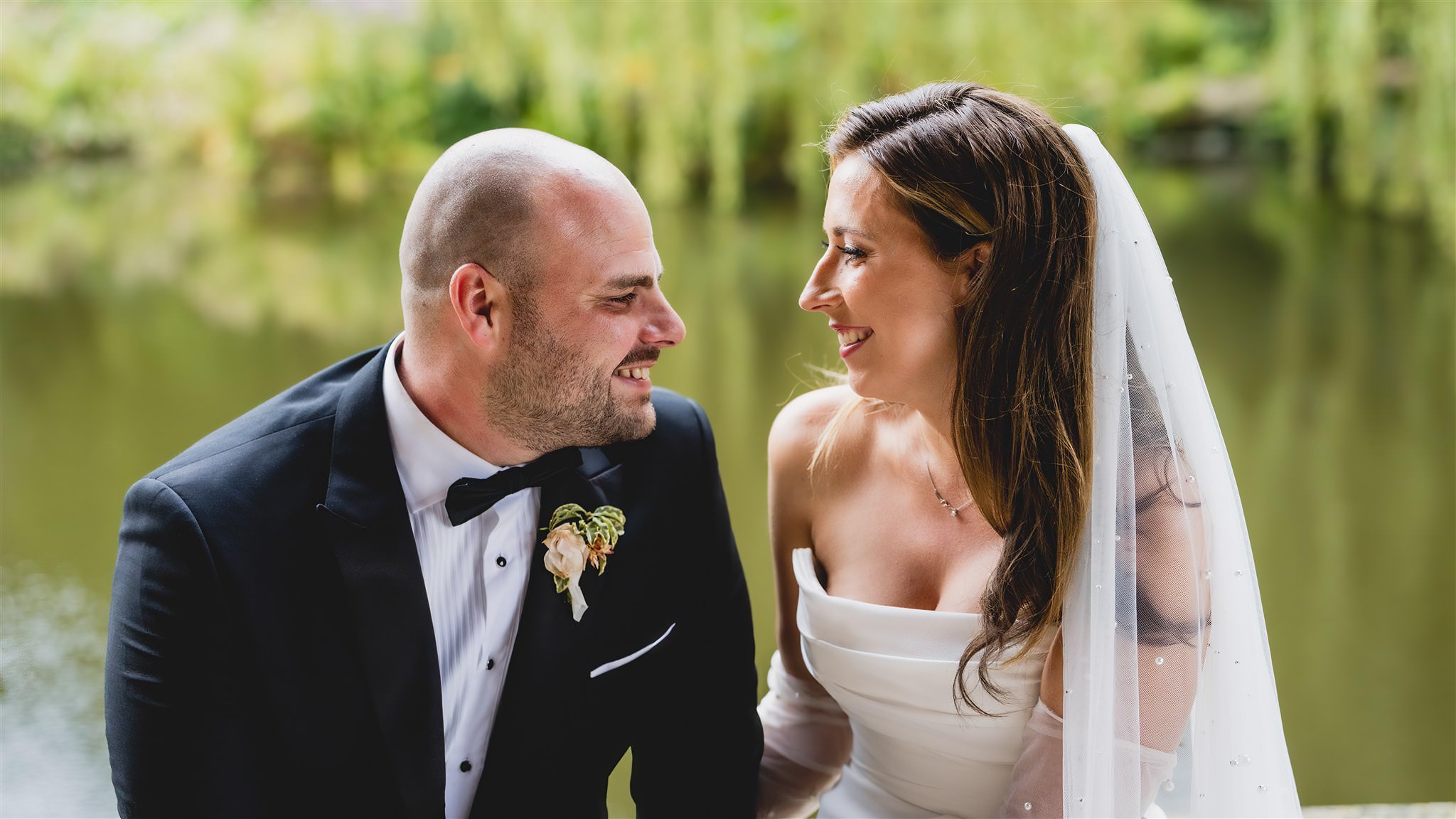 Couple sitting close together by the water at The Dairy, Waddesdon