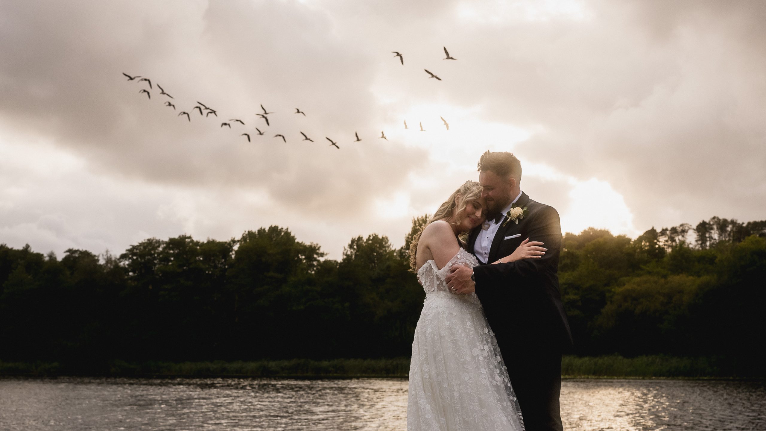 Bethan and Jake by the lake at sunset as geese fly over Hensol Castle