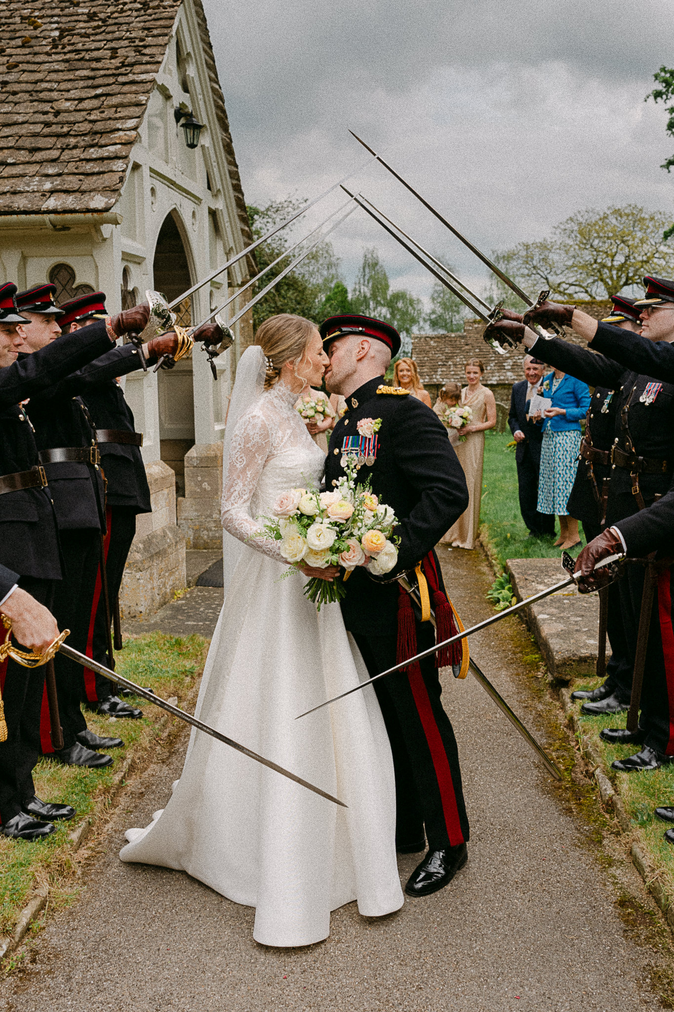 Becca and Liam walking through a sword arch after their ceremony