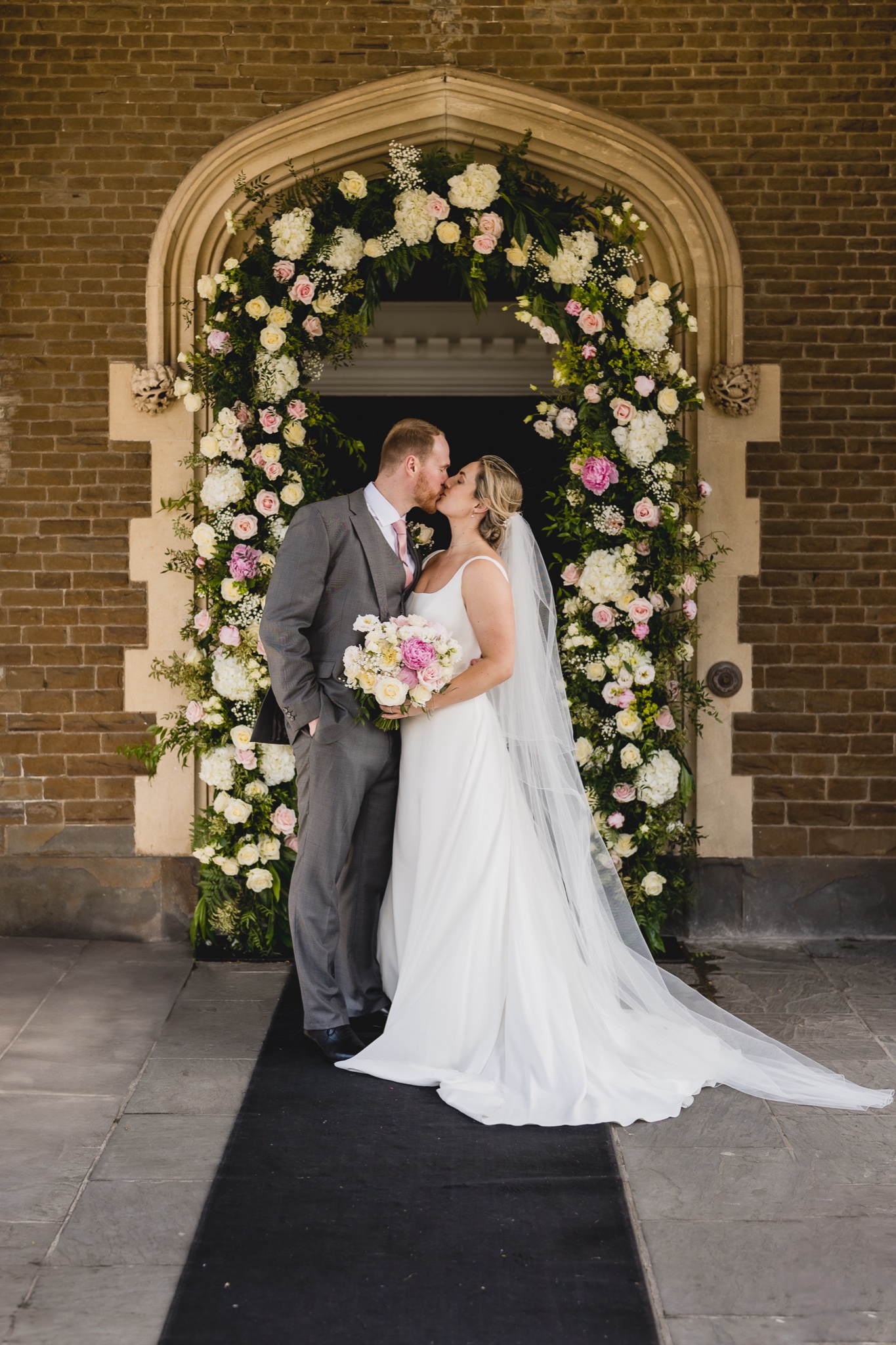 Natalie and Jake in the flower-arched doorway of the castle
