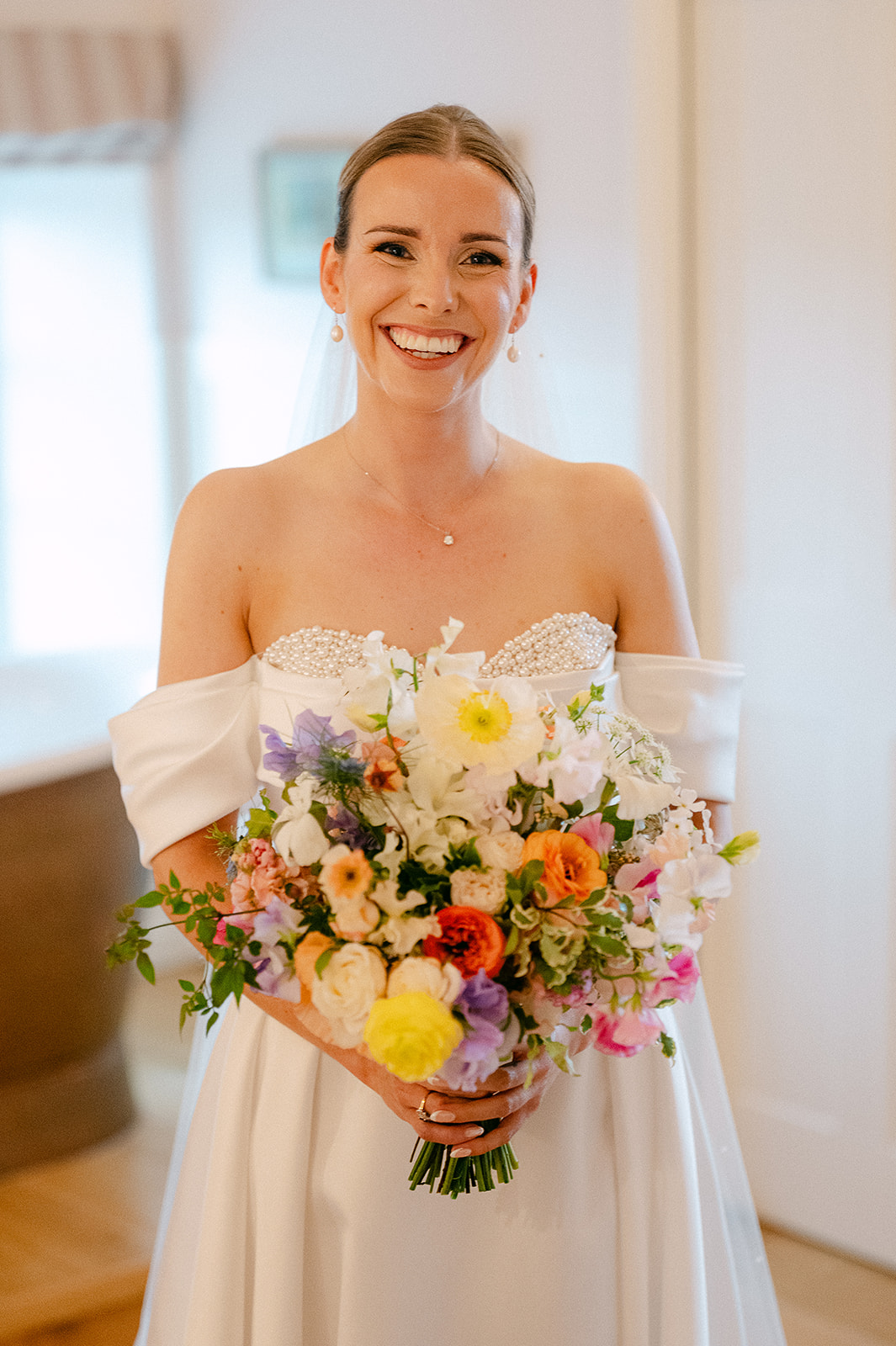 Olivia smiling with her bouquet before the ceremony