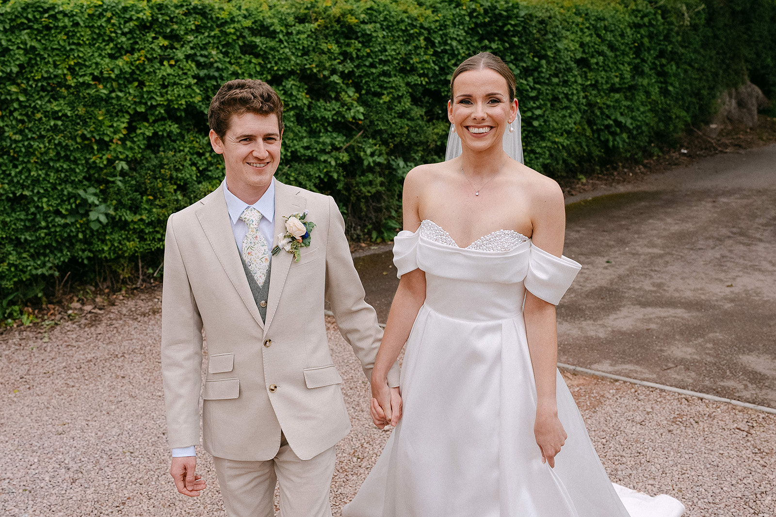Olivia and Nathan walking hand in hand along the farm drive