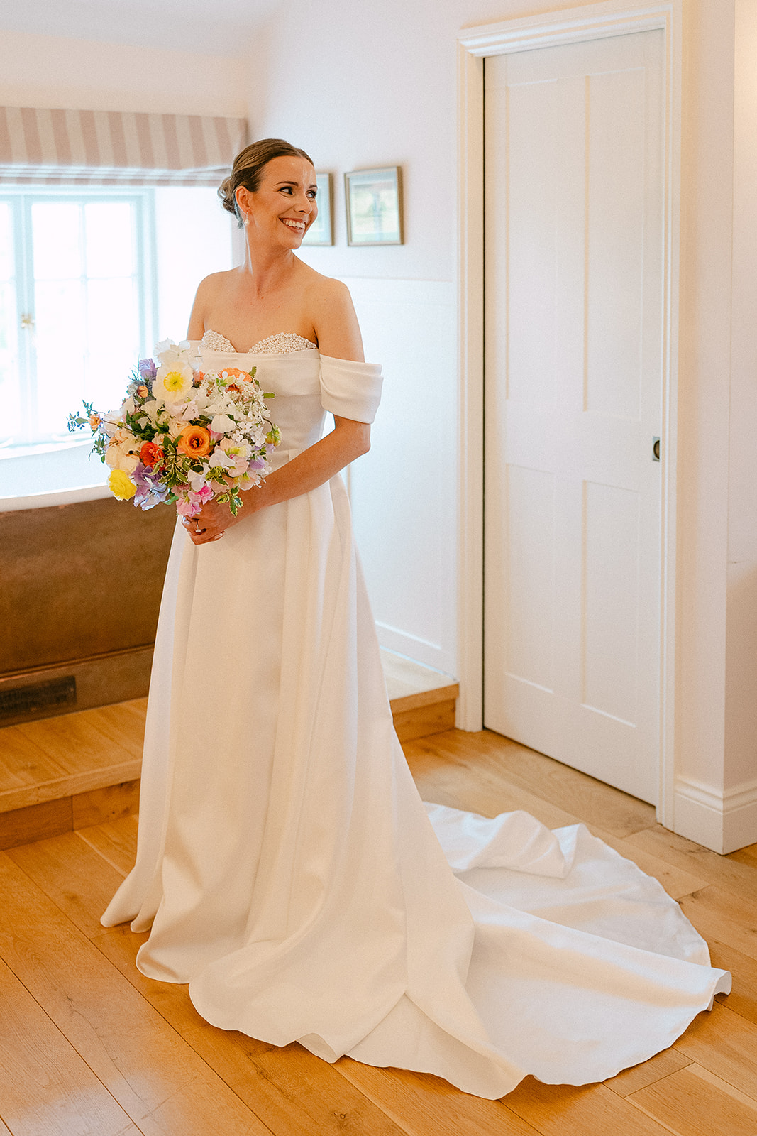 Olivia in her dress with her bouquet in the bedroom