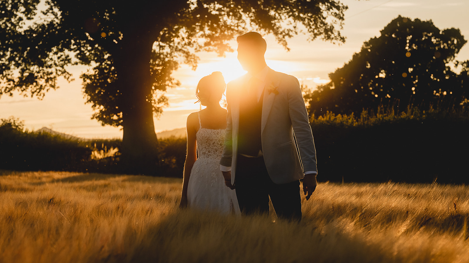 Rosie and Ben silhouetted by the setting sun under the tree