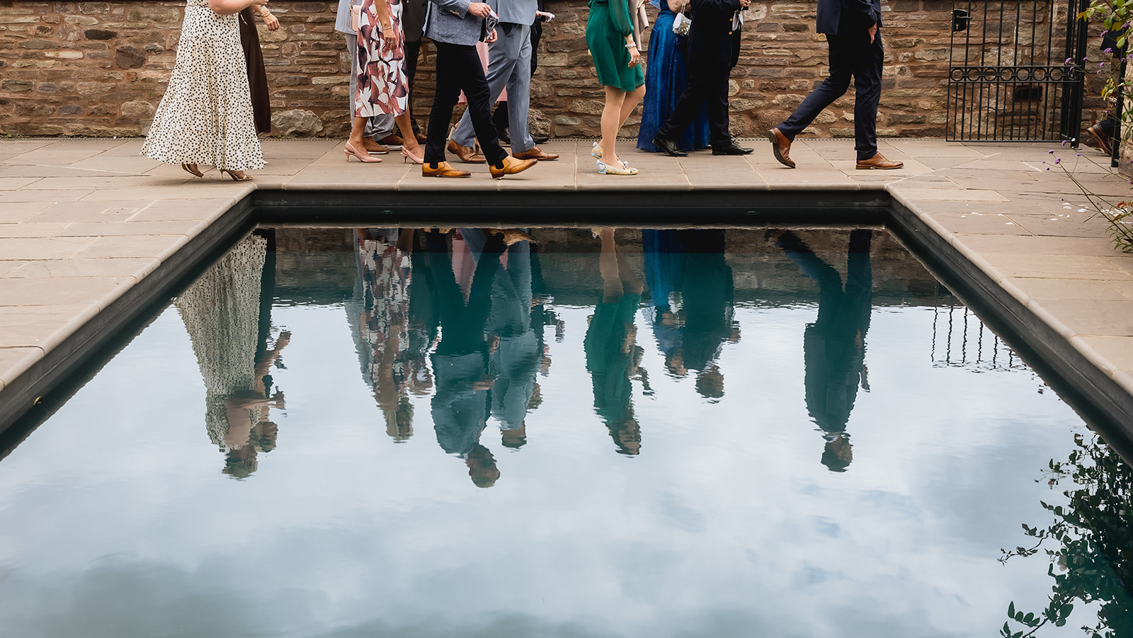 Guests reflected in the still water of the pool