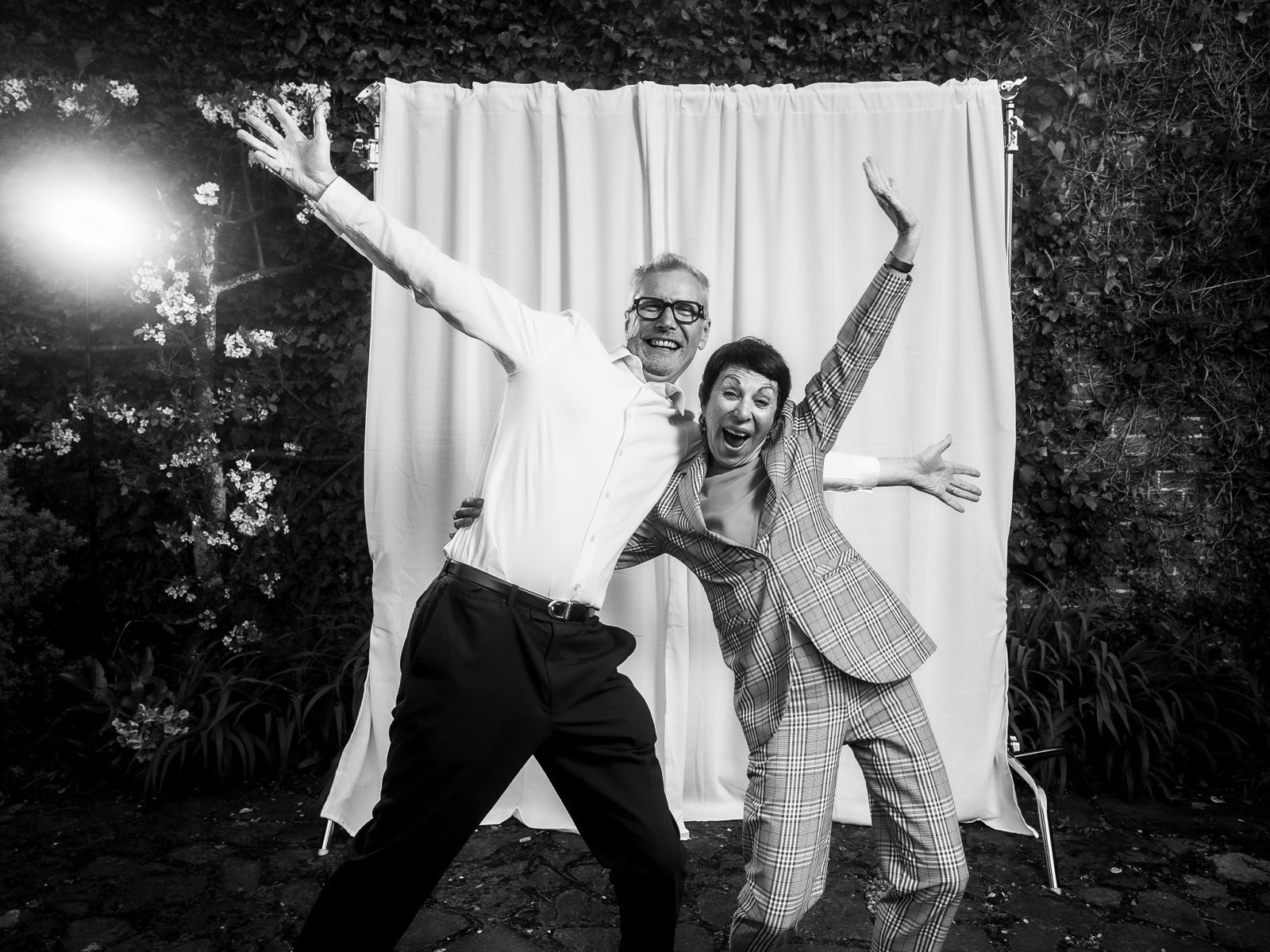 Two guests leaping in front of the curtain at night