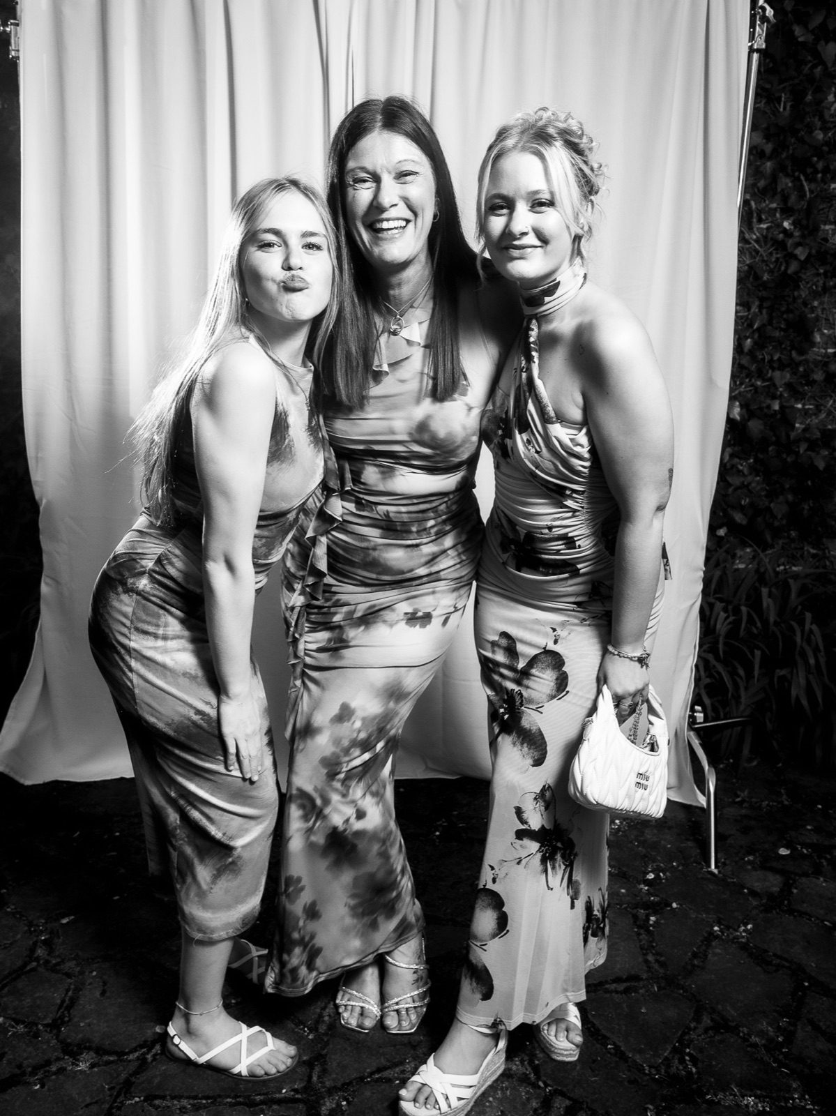 Three friends in floral dresses posing together