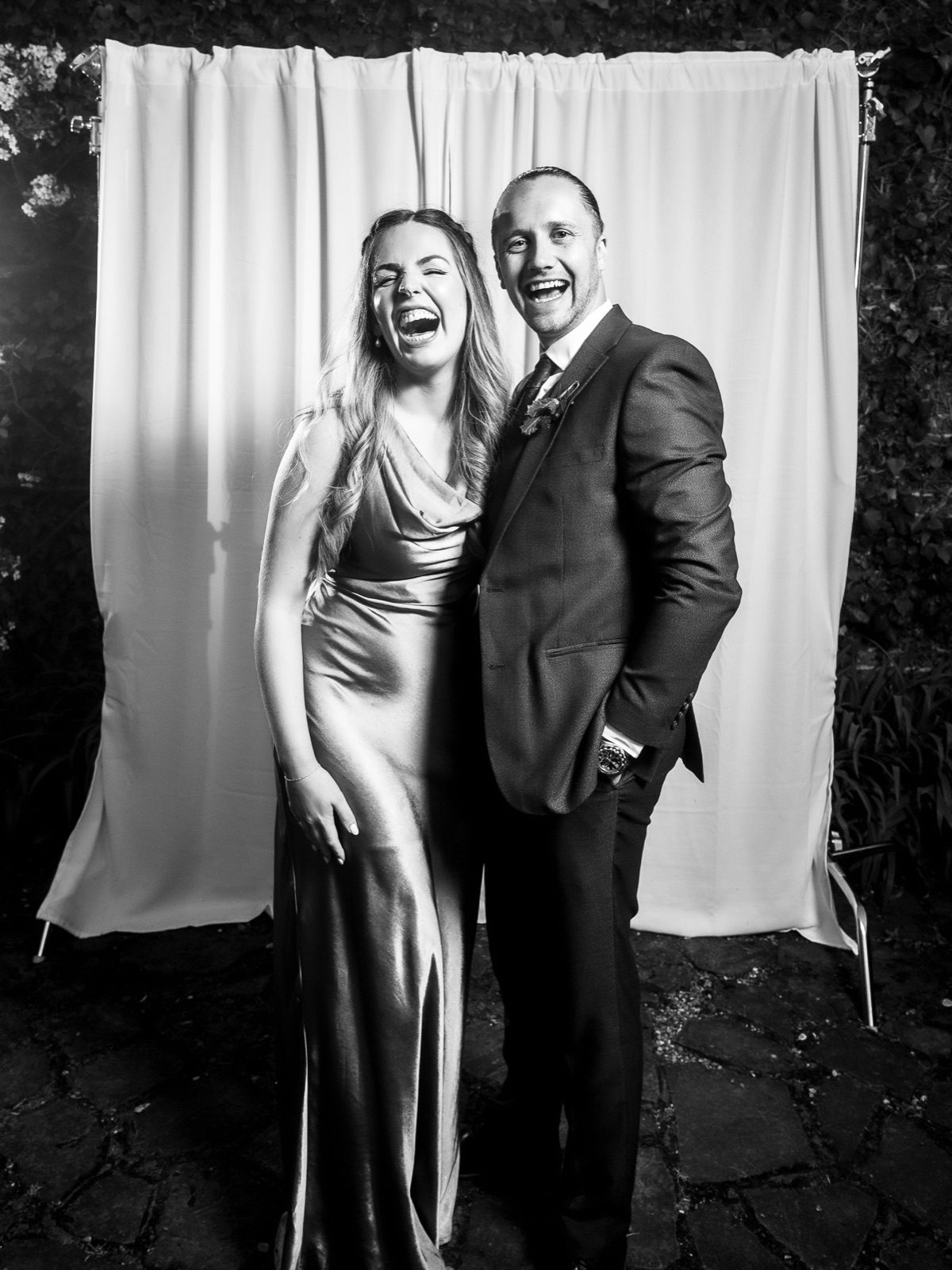 A couple of guests laughing, black and white portrait