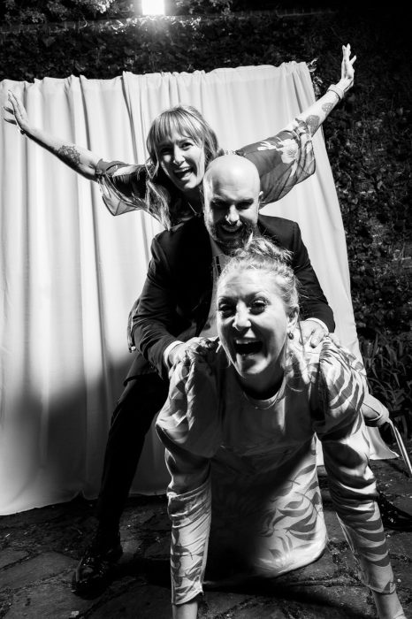 Three guests piled on top of each other, mid-laugh