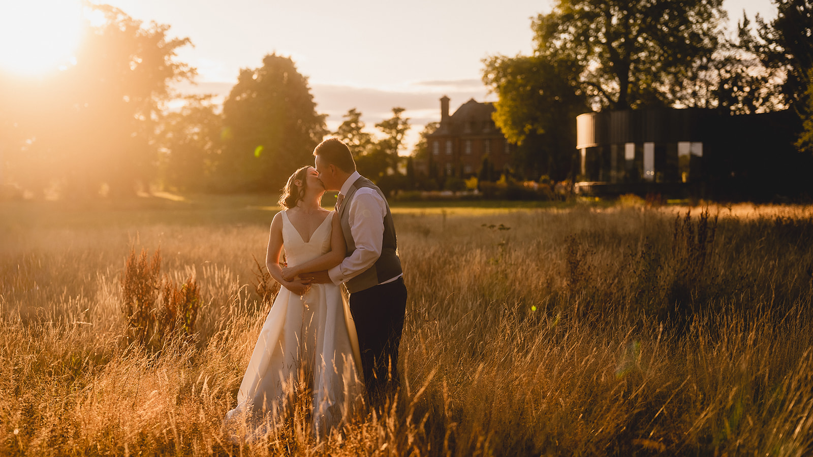 Flic and Ben in the golden meadow with the house beyond