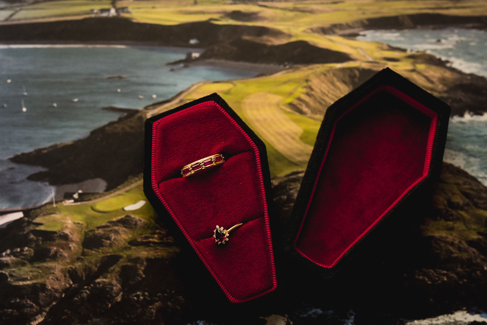 Rings in red velvet coffin boxes on an aerial photograph