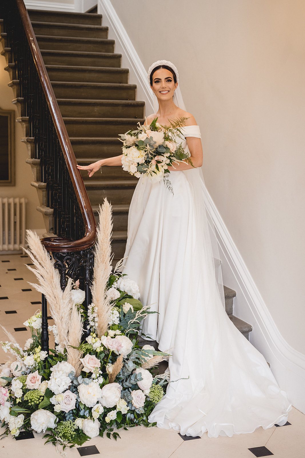 Emily on the staircase with her bouquet