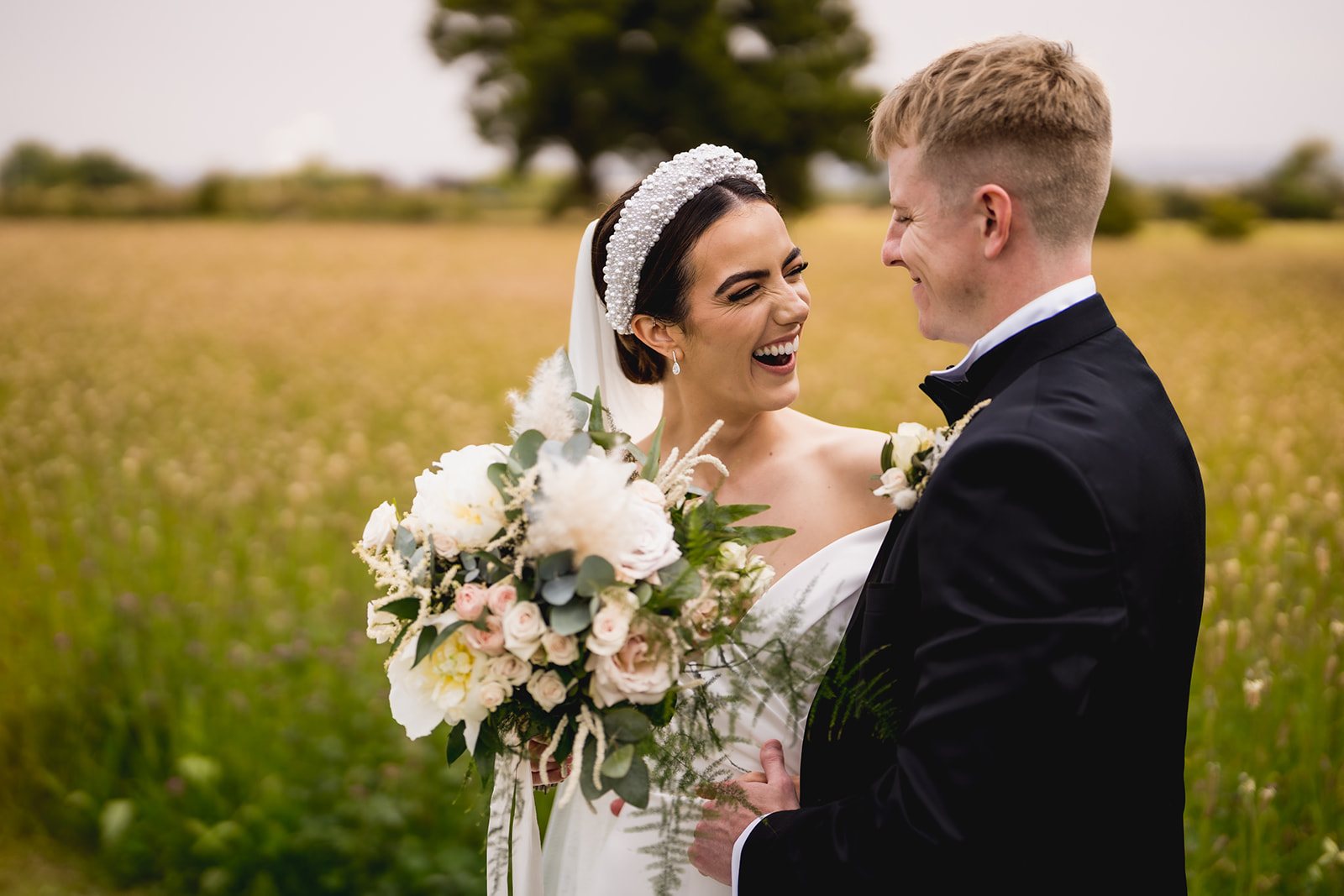 Emily and Craig laughing together in the wildflower meadow