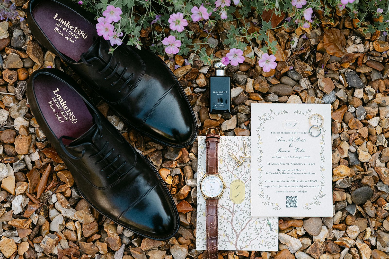 Groom’s shoes, watch and the invitation on gravel