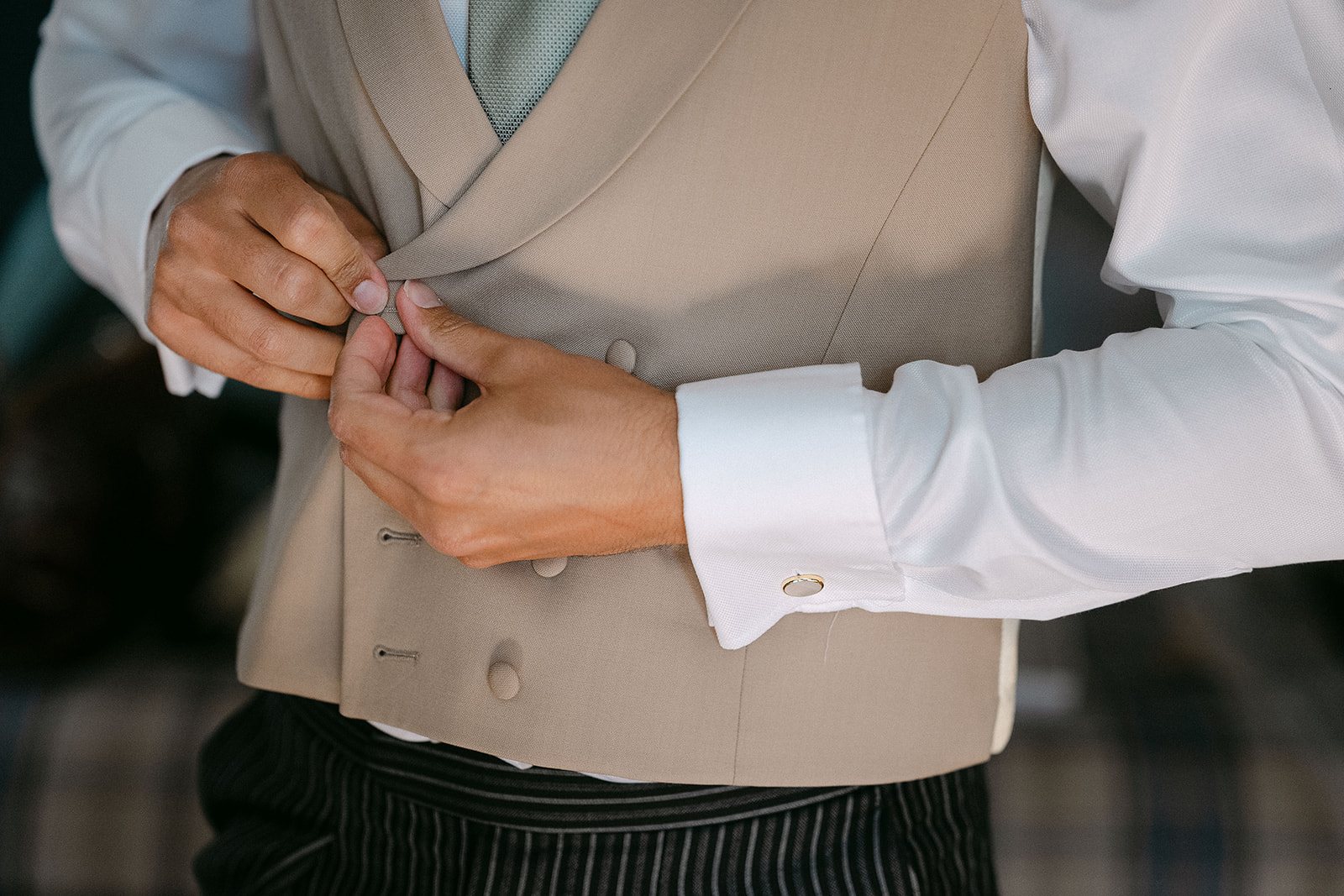 Fastening the waistcoat buttons