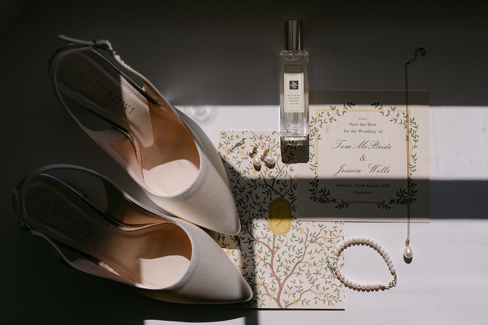 Wedding shoes, perfume and the invitation on a table