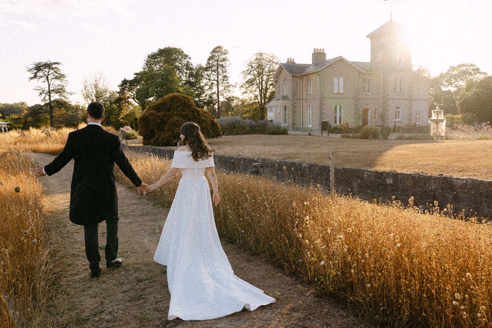 Jess and Tom walking the meadow path towards the house